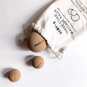 cork massage balls rolling out of canvas bag on white background