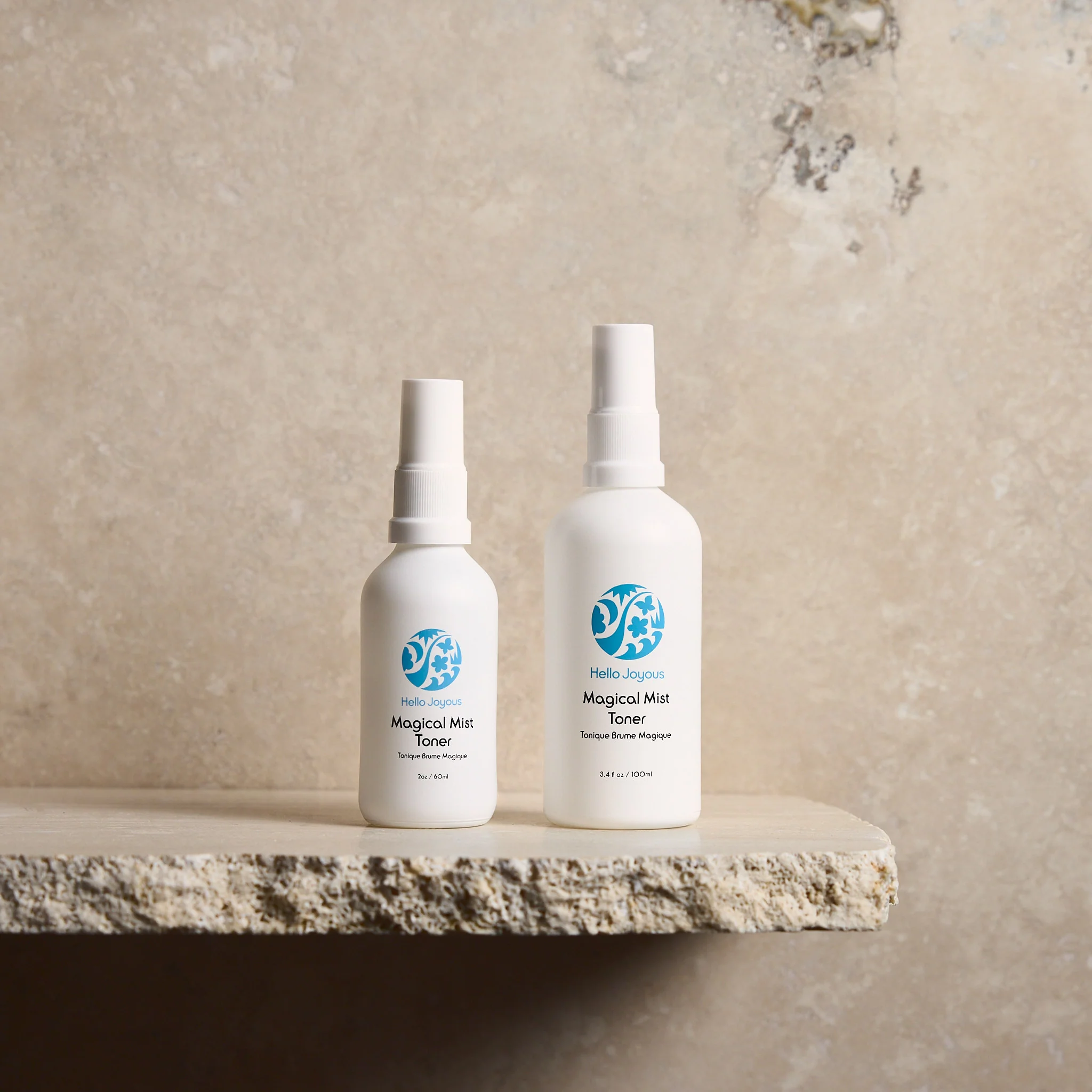 Magical mist toner bottles in both 60ml and 100ml sizes against plain backdrop