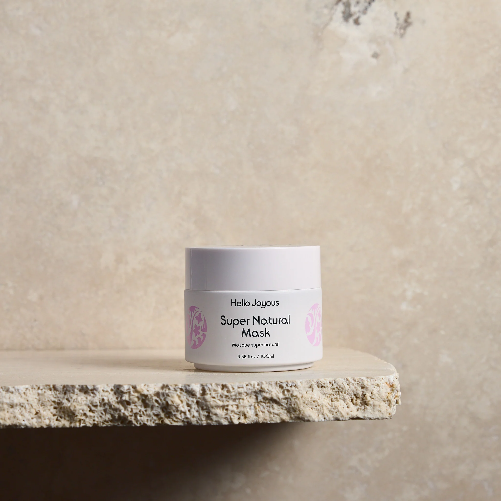 super natural mask in twist cap jar against plain backdrop a product image