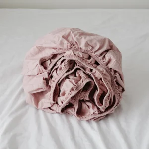 fitted sheet rolled in primrose colour against white sheet